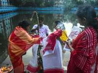 Hindu devotees perform prayers in front of a banana tree trunk as part of a ritual Nabapatrika on the banks of the Ganges River during the D...