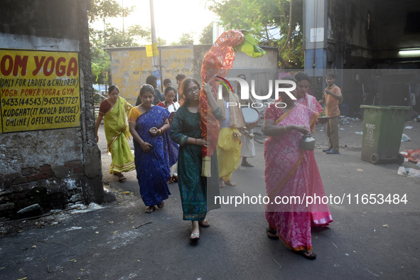 A lady carries a banana tree trunk during a ritual Nabapatrika as part of the Durga Puja festival in the early morning in Kolkata, India, on...