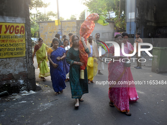 A lady carries a banana tree trunk during a ritual Nabapatrika as part of the Durga Puja festival in the early morning in Kolkata, India, on...