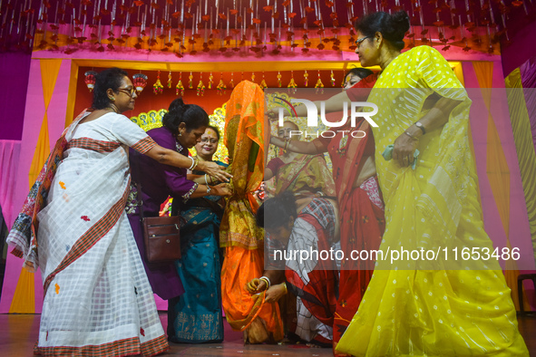 Women hold a banana tree trunk during a ritual Nabapatrika as part of the Durga Puja festival in Kolkata, India, on October 10, 2024. 