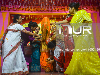 Women hold a banana tree trunk during a ritual Nabapatrika as part of the Durga Puja festival in Kolkata, India, on October 10, 2024. (