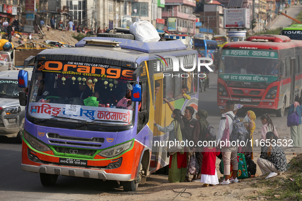 People board a bus as they return home for the fortnightly festival of Dashain in Kathmandu, Nepal, on October 10, 2024. 