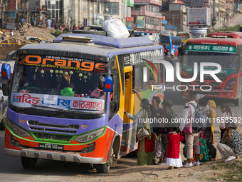 People board a bus as they return home for the fortnightly festival of Dashain in Kathmandu, Nepal, on October 10, 2024. (