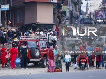 People wait for vehicles at the roadside as they prepare to return home for the fortnightly festival of Dashain in Kathmandu, Nepal, on Octo...