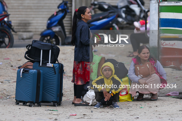 People wait for vehicles at the roadside as they prepare to return home for the fortnightly festival of Dashain in Kathmandu, Nepal, on Octo...