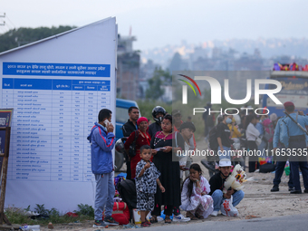 People wait for vehicles at the roadside as they prepare to return home for the fortnightly festival of Dashain in Kathmandu, Nepal, on Octo...