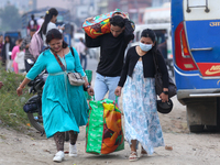 People carry their bags and luggage as they prepare to return to their permanent homes from Kathmandu, Nepal, on October 10, 2024, to celebr...