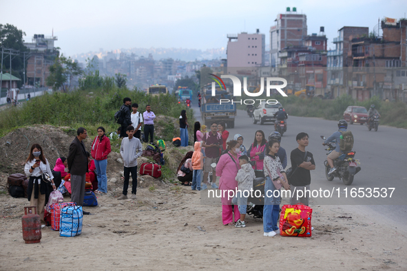 People wait for vehicles at the roadside as they prepare to return home for the fortnightly festival of Dashain in Kathmandu, Nepal, on Octo...