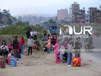 People wait for vehicles at the roadside as they prepare to return home for the fortnightly festival of Dashain in Kathmandu, Nepal, on Octo...