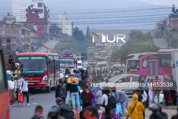 People wait for vehicles at the roadside as they prepare to return home for the fortnightly festival of Dashain in Kathmandu, Nepal, on Octo...