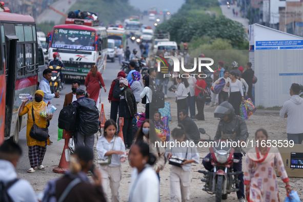 People wait for vehicles at the roadside as they prepare to return home for the fortnightly festival of Dashain in Kathmandu, Nepal, on Octo...