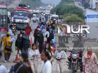 People wait for vehicles at the roadside as they prepare to return home for the fortnightly festival of Dashain in Kathmandu, Nepal, on Octo...