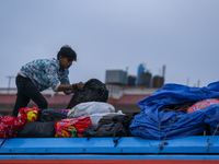 The staff of a passenger vehicle arranges luggage on top of the vehicle as it prepares to depart from Kathmandu, Nepal, on October 10, 2024....