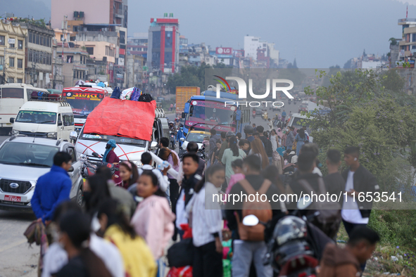 People wait for vehicles at the roadside as they prepare to return home for the fortnightly festival of Dashain in Kathmandu, Nepal, on Octo...