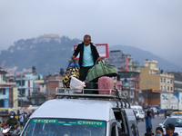 The staff of a passenger bus arranges luggage on top of the vehicle as it prepares to depart from Kathmandu, Nepal, on October 10, 2024. Tho...