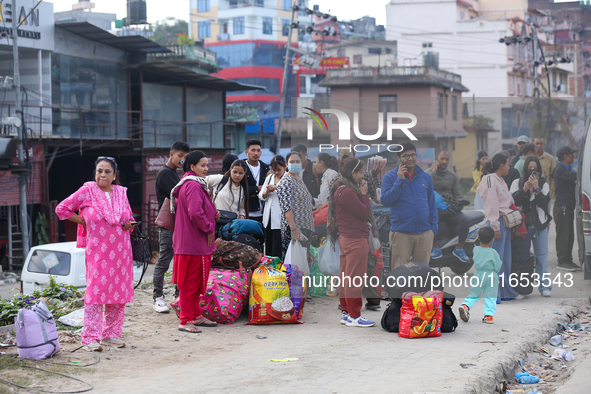 People wait for vehicles at the roadside as they prepare to return home for the fortnightly festival of Dashain in Kathmandu, Nepal, on Octo...