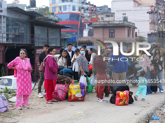 People wait for vehicles at the roadside as they prepare to return home for the fortnightly festival of Dashain in Kathmandu, Nepal, on Octo...