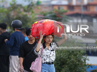 People carry their bags and luggage as they prepare to return to their permanent homes from Kathmandu, Nepal, on October 10, 2024, to celebr...