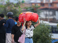 People carry their bags and luggage as they prepare to return to their permanent homes from Kathmandu, Nepal, on October 10, 2024, to celebr...