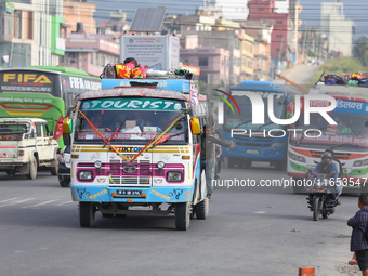 The staff of a passenger bus calls for passengers as it departs from Kathmandu, Nepal, on October 10, 2024. Thousands of people leave the Ne...