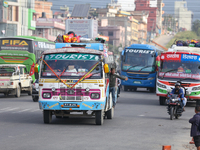 The staff of a passenger bus calls for passengers as it departs from Kathmandu, Nepal, on October 10, 2024. Thousands of people leave the Ne...