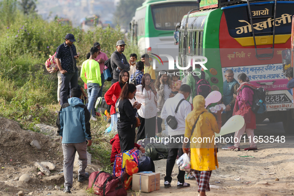 People wait for vehicles at the roadside as they prepare to return home for the fortnightly festival of Dashain in Kathmandu, Nepal, on Octo...