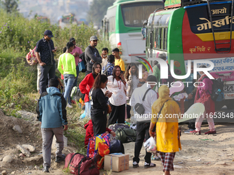 People wait for vehicles at the roadside as they prepare to return home for the fortnightly festival of Dashain in Kathmandu, Nepal, on Octo...