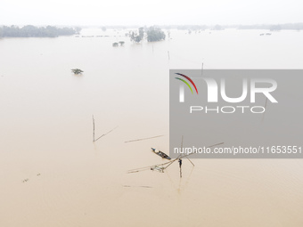 Fishermen create fishing grounds with bamboo and catch various types of fish with nets from the flooded open ghat in Jhenaigati Upazila of S...