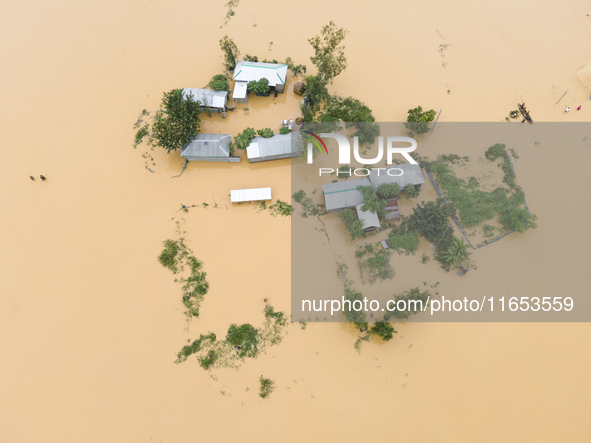 Heavy rains and water from upstream India submerge homes in a village in Jhenaigati upazila of Sherpur district, Bangladesh, on October 5, 2...