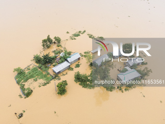 Heavy rains and water from upstream India submerge homes in a village in Jhenaigati upazila of Sherpur district, Bangladesh, on October 5, 2...