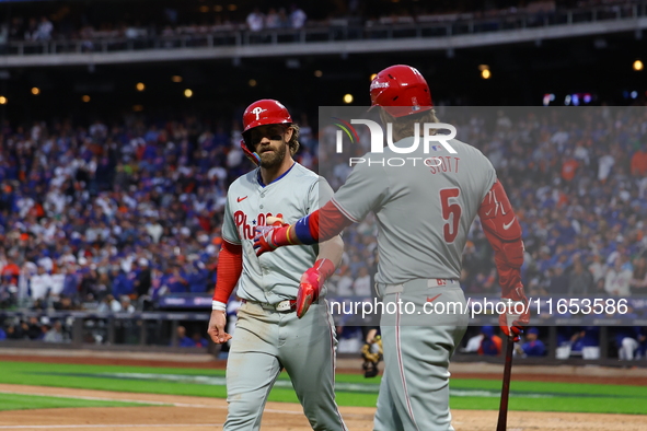 Bryce Harper #3 of the Philadelphia Phillies is congratulated after scoring during the fourth inning in Game 4 of the baseball NL Division S...