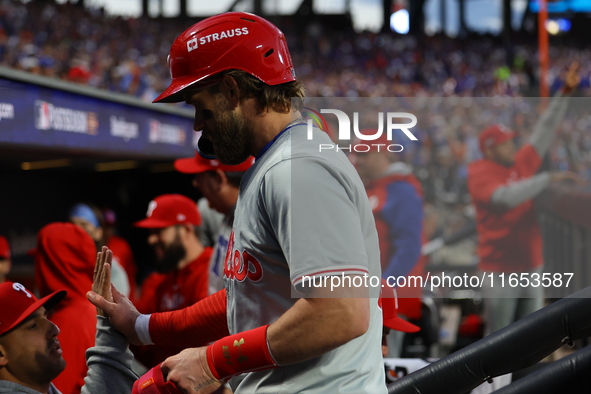 Bryce Harper #3 of the Philadelphia Phillies is congratulated after scoring during the fourth inning in Game 4 of the baseball NL Division S...