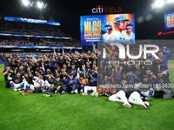 New York Mets players and staff pose for a photo after winning the NLDS against the Philadelphia Phillies at Citi Field in Flushing, N.Y., o...