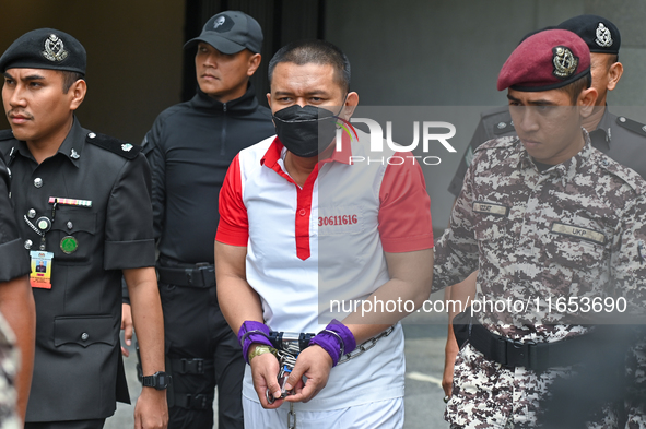 Mongolian model Altantuya Shaariibuu's murderer, Azilah Hadri, is escorted by the prison guards outside the Federal Court in Putrajaya, Mala...