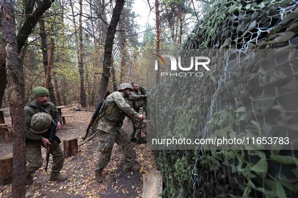 Soldiers of Ukraine's 154th Separate Mechanized Brigade man a 2S1 Gvozdika self-propelled howitzer covered with camouflage netting at positi...