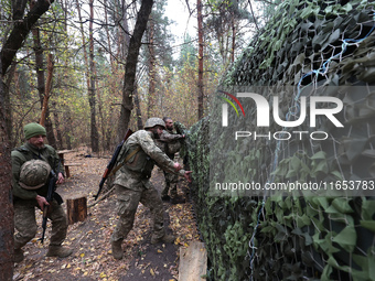 Soldiers of Ukraine's 154th Separate Mechanized Brigade man a 2S1 Gvozdika self-propelled howitzer covered with camouflage netting at positi...