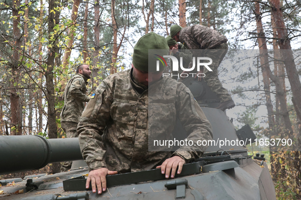 Soldiers of Ukraine's 154th Separate Mechanized Brigade man a 2S1 Gvozdika self-propelled howitzer covered with camouflage netting at positi...