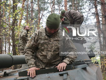 Soldiers of Ukraine's 154th Separate Mechanized Brigade man a 2S1 Gvozdika self-propelled howitzer covered with camouflage netting at positi...