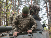 Soldiers of Ukraine's 154th Separate Mechanized Brigade man a 2S1 Gvozdika self-propelled howitzer covered with camouflage netting at positi...