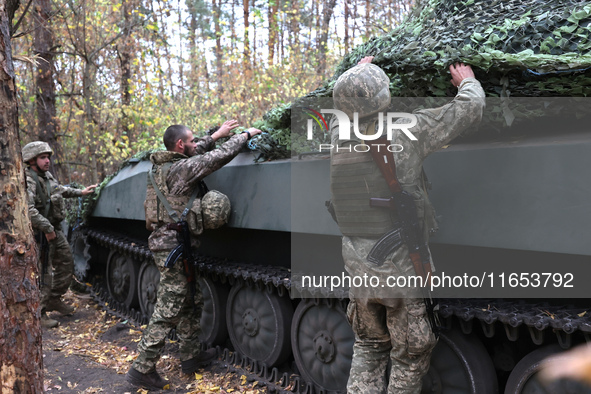 Soldiers of Ukraine's 154th Separate Mechanized Brigade man a 2S1 Gvozdika self-propelled howitzer covered with camouflage netting at positi...