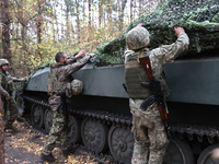 Soldiers of Ukraine's 154th Separate Mechanized Brigade man a 2S1 Gvozdika self-propelled howitzer covered with camouflage netting at positi...