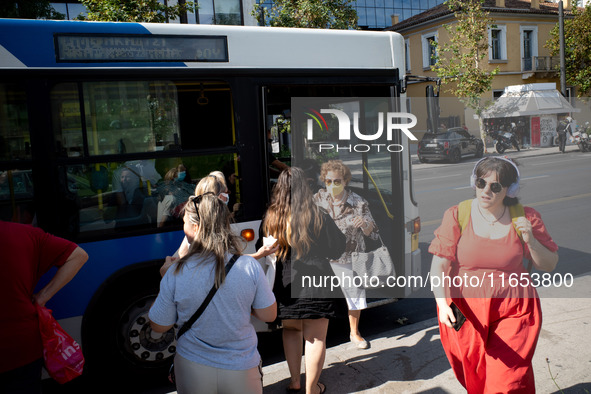 A woman exits the front door of the bus in the center of Athens, Greece, on October 10, 2024. A new measure for public transportation is ann...