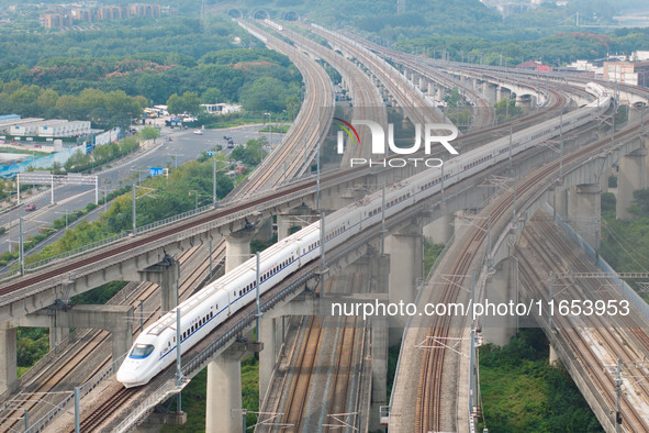 A bullet train runs near Nanjing South Railway Station in Nanjing, China, on October 10, 2024. 