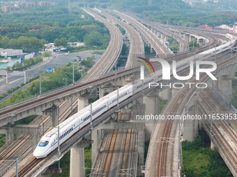 A bullet train runs near Nanjing South Railway Station in Nanjing, China, on October 10, 2024. (