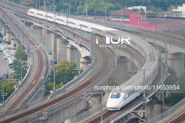 A bullet train runs near Nanjing South Railway Station in Nanjing, China, on October 10, 2024. 