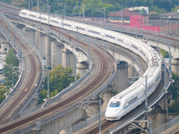 A bullet train runs near Nanjing South Railway Station in Nanjing, China, on October 10, 2024. (