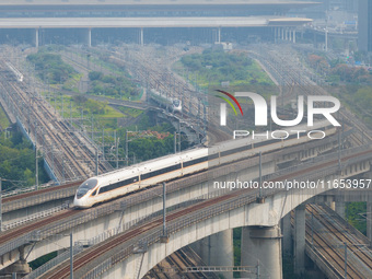 A bullet train runs near Nanjing South Railway Station in Nanjing, China, on October 10, 2024. (