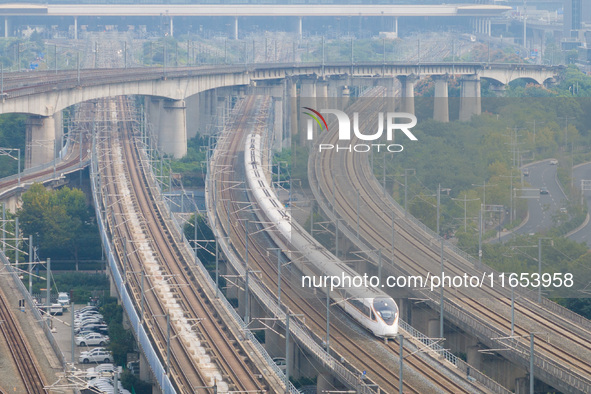 A bullet train runs near Nanjing South Railway Station in Nanjing, China, on October 10, 2024. 