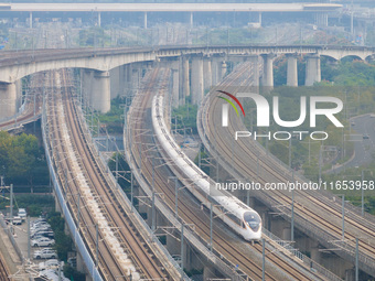 A bullet train runs near Nanjing South Railway Station in Nanjing, China, on October 10, 2024. (