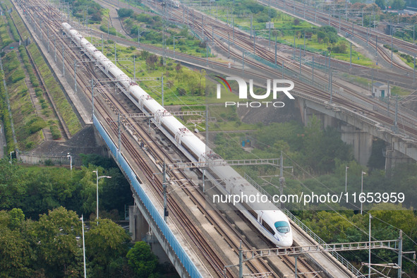 A bullet train runs near Nanjing South Railway Station in Nanjing, China, on October 10, 2024. 